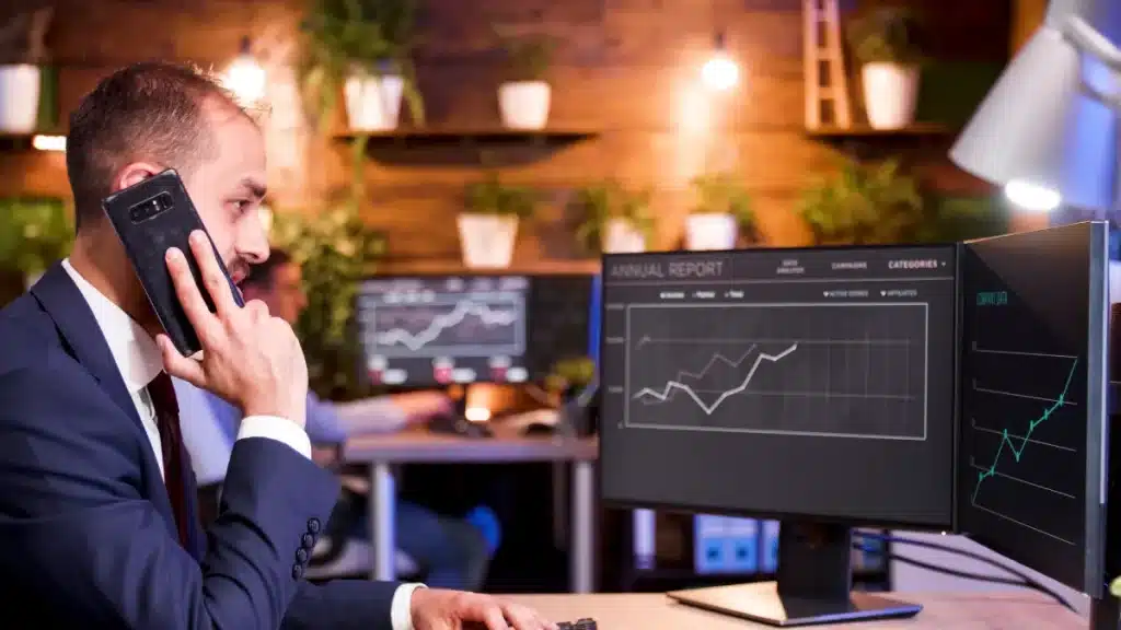 businessman talking phone while working computer modern office